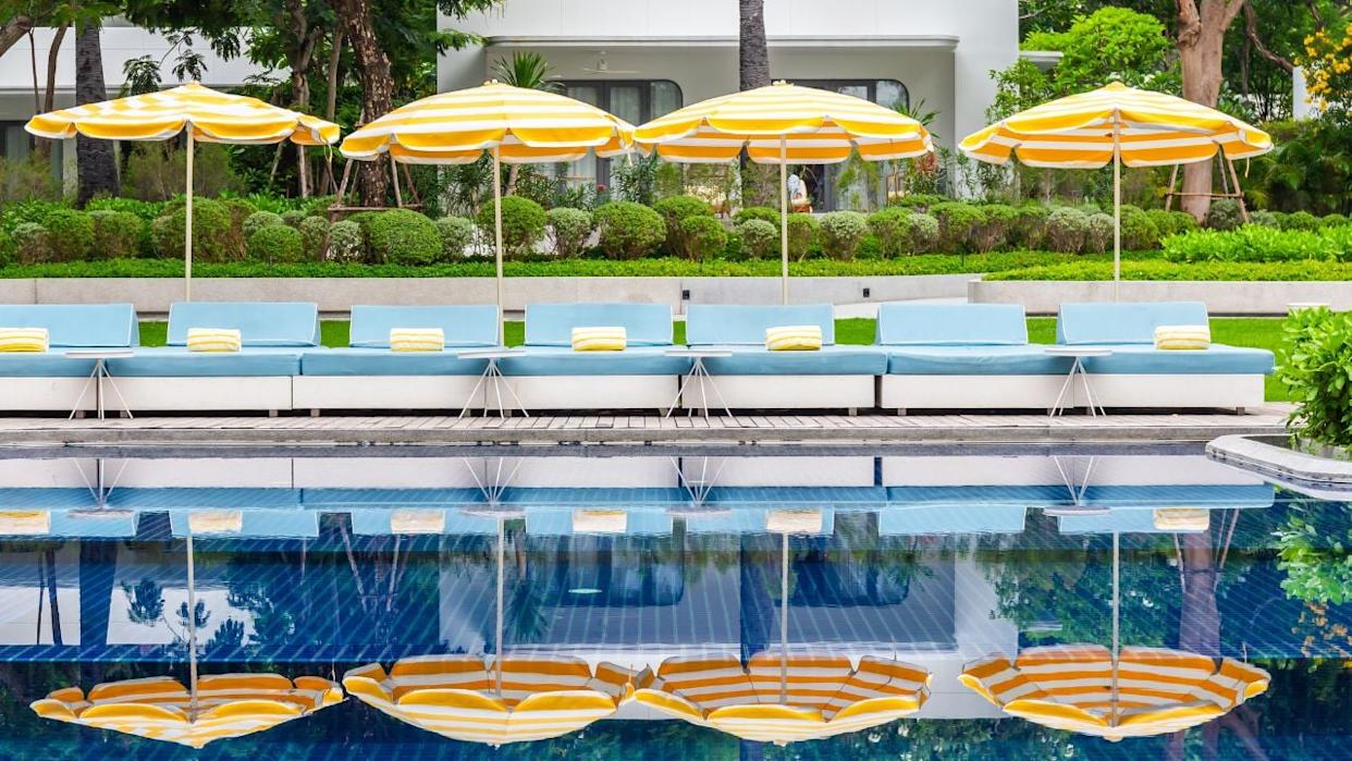 A bright, family-friendly hotel pool with lounge seating and palm-lined surroundings offers a comfortable stay near Disneyland in Anaheim