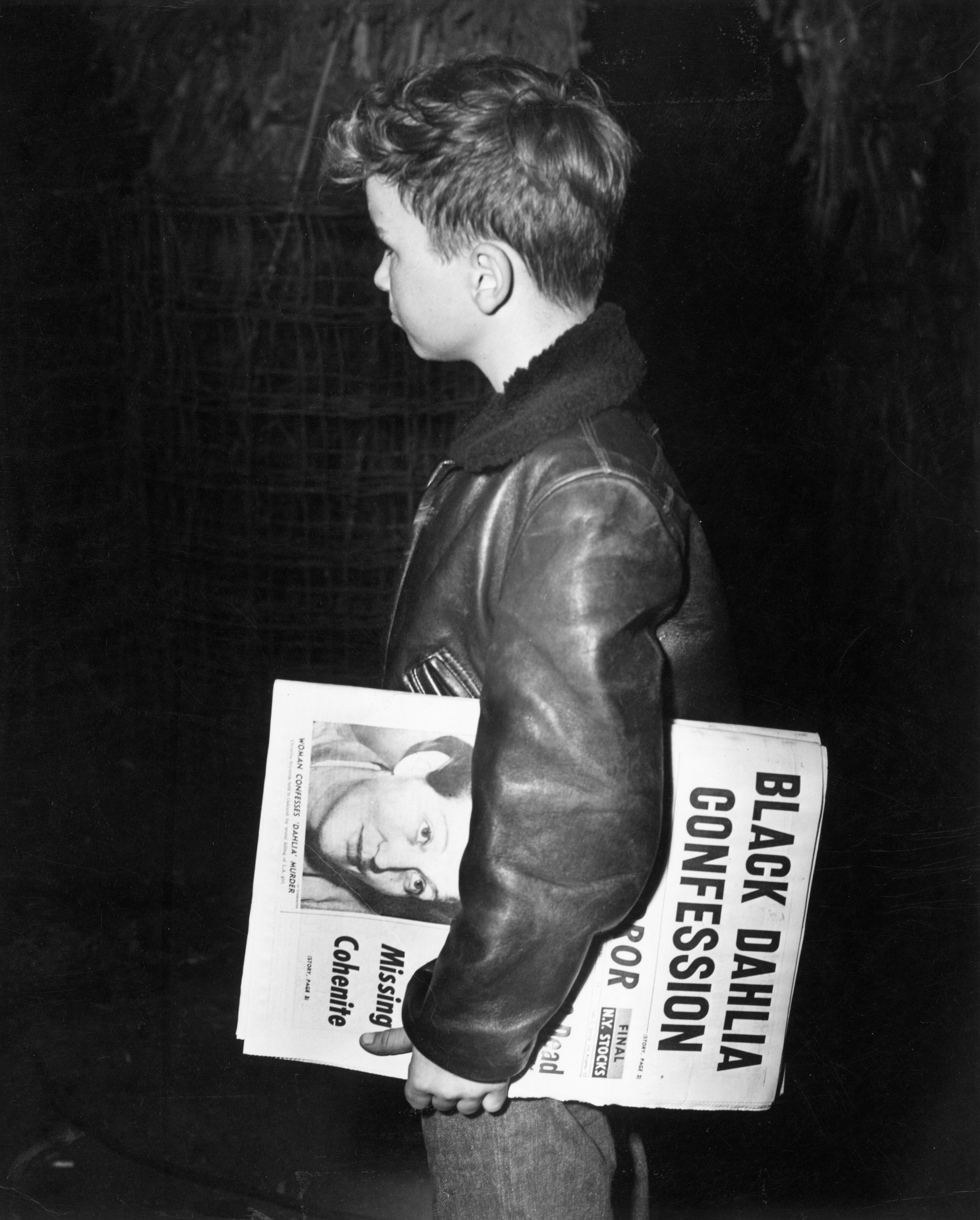 A 1940s-era boy holds a newspaper that reads: "Black Dahlia Confession."