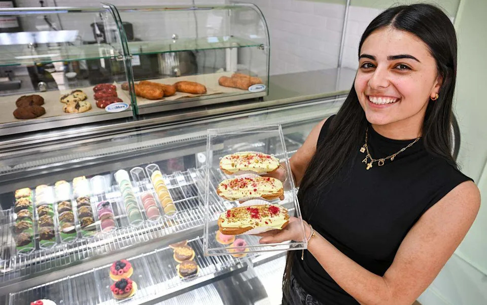 Arpi Keymetlyan holds up a trio of pistachio eclairs while standing in front of a case of various treats and baked goods at Lodéi Bakery & Cafe, an Armenian family-owned bakery on the northeast corner of Palm and Bullard avenues.