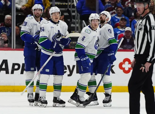Apr 1, 2026; Denver, Colorado, USA; Members of the Vancouver Canucks celebrate a third period empty net goal by right wing Brock Boeser (6) against the Colorado Avalanche at Ball Arena.