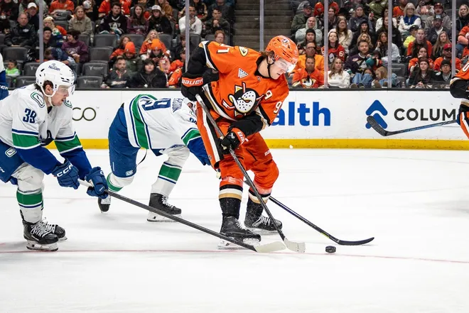 Apr 12, 2026; Anaheim, California, USA; Anaheim Ducks center Leo Carlsson (91) skates with the puck against Vancouver Canucks center Ty Mueller (39) during the second period at Honda Center.