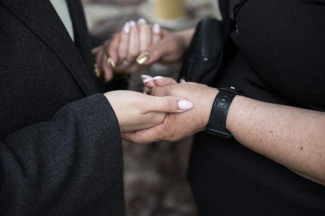 Ivonne Rodriguez, left, holds Maria de Jesus Estrada Juarez hands as Estrada Juarez prays for a safe return to California while they wait in Rosarito, Mexico for permission to return to the United States on Monday, March 30, 2026. 
