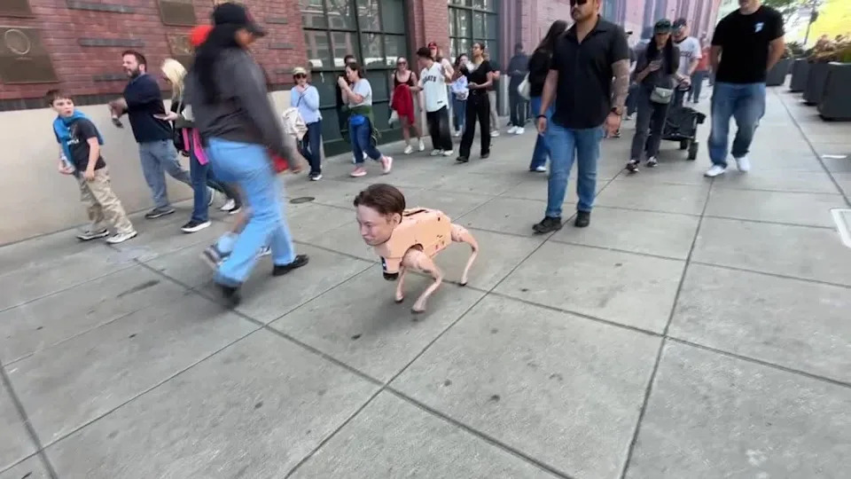 <div>An autonomous robot head of Elon Musk struts around San Francisco outside a Giants game at Oracle Park. April 8, 2026</div>
