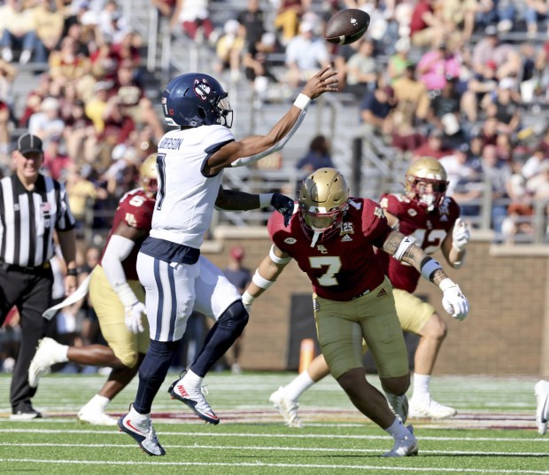 UConn quarterback Ta'Quan Roberson (1) releases a pass as Boston College defensive back Sione Hala (7) closes in on him during the first half of an NCAA college football game Saturday, Oct. 28, 2023 in Boston. (AP Photo/Mark Stockwell)