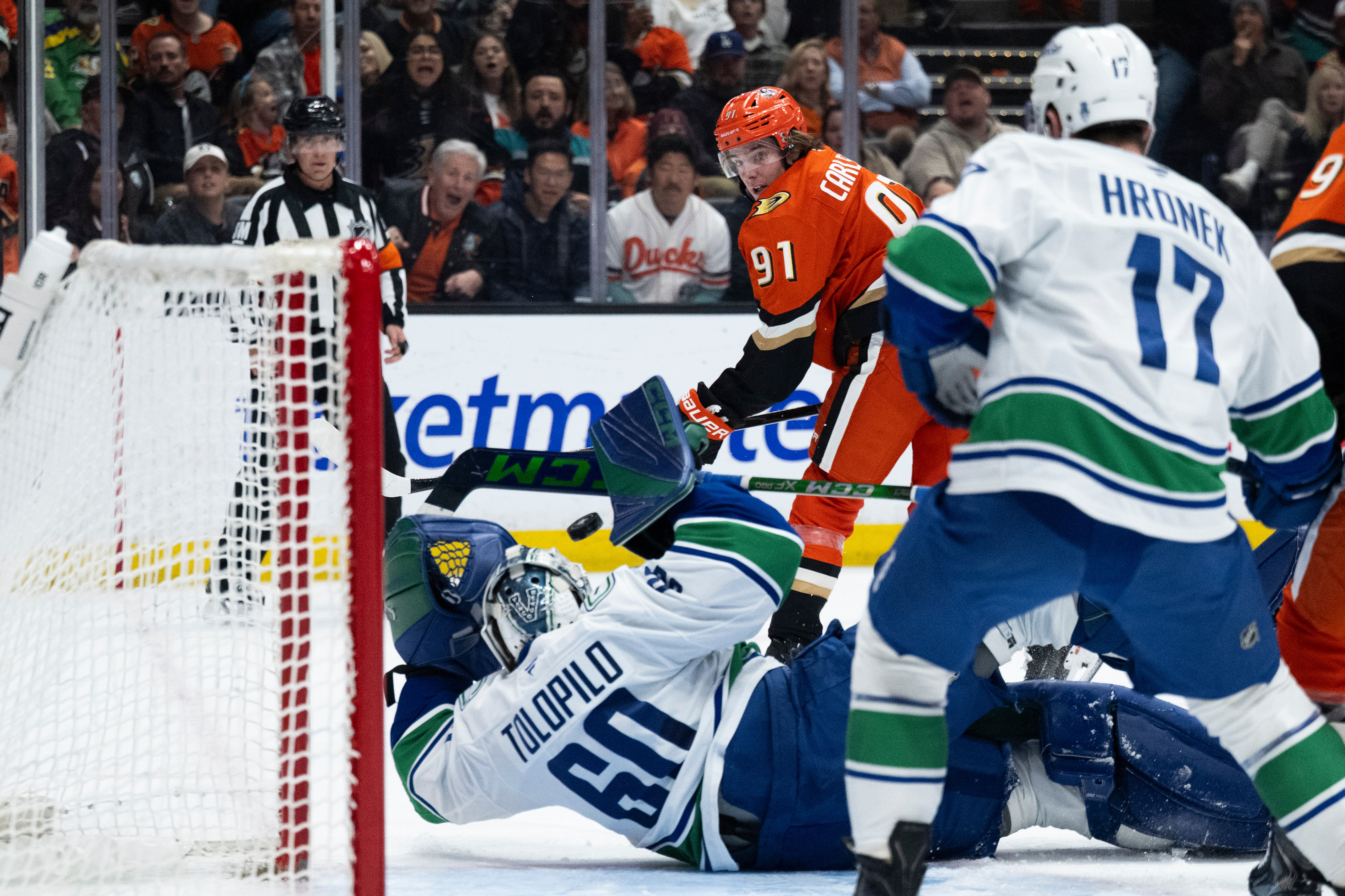 Ducks center Leo Carlsson, top, scores past Vancouver Canucks goaltender...