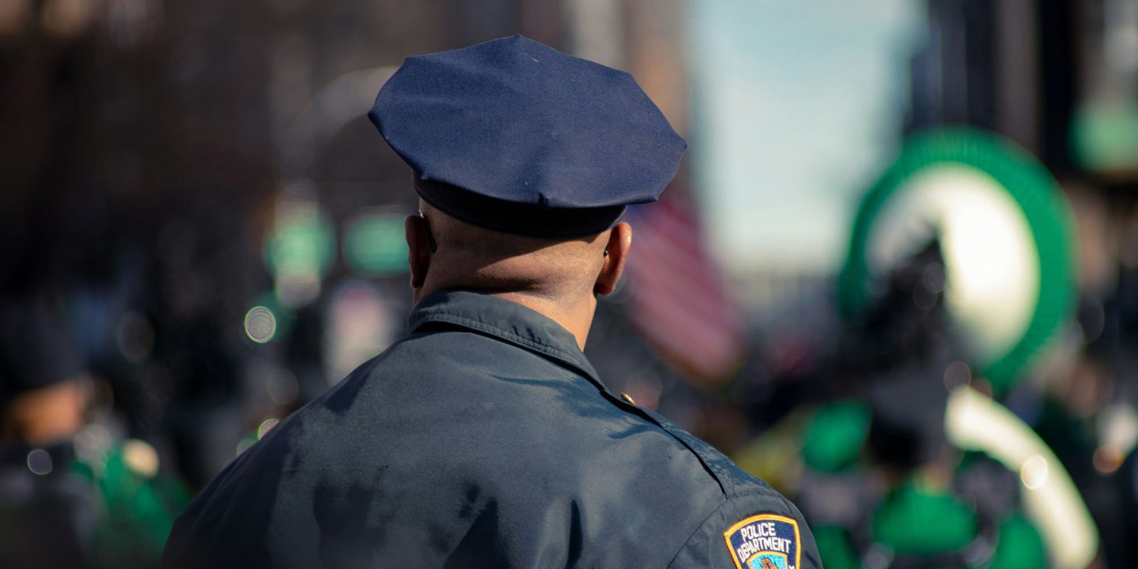 Apple paid $1.2M to privately hire police to protect its San Francisco stores – Wired | Stock photo shows a police officer photographed from behind