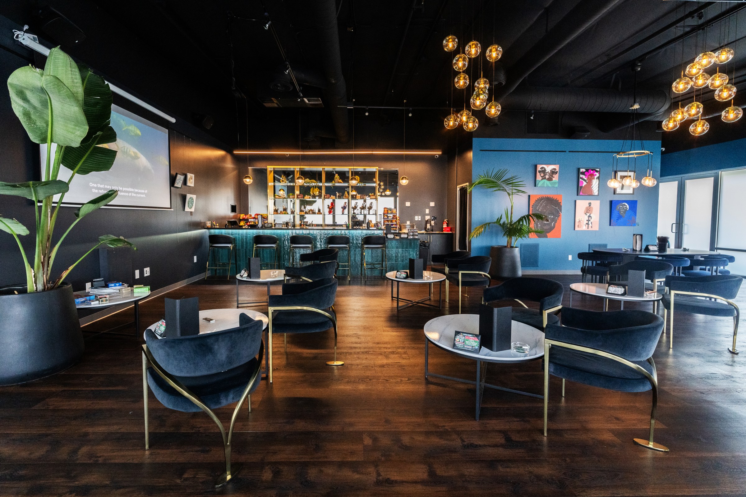 Cannabis lounge at Artist Tree Hawthorne with plants, chairs, tables, and a bar.