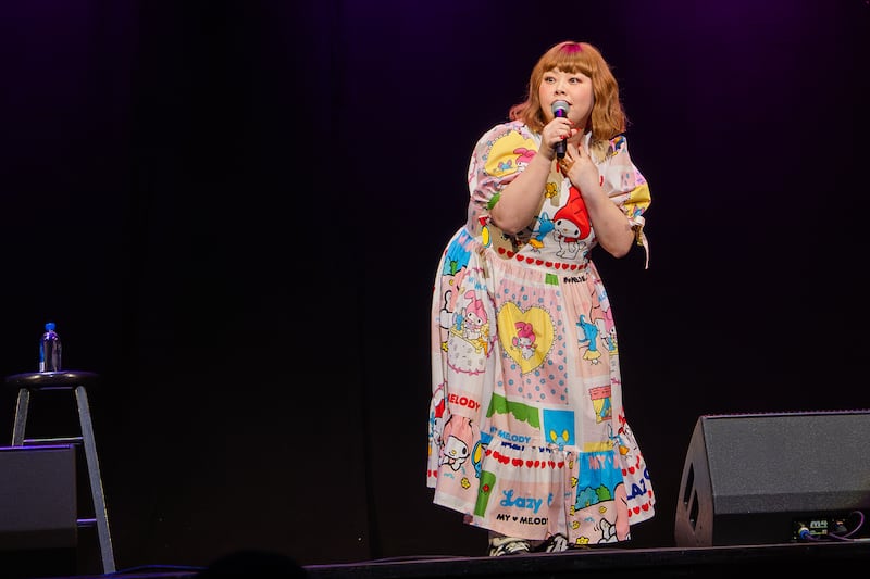 Watanabe Naomi's left hand on her chest as she describes her experience living in the U.S.