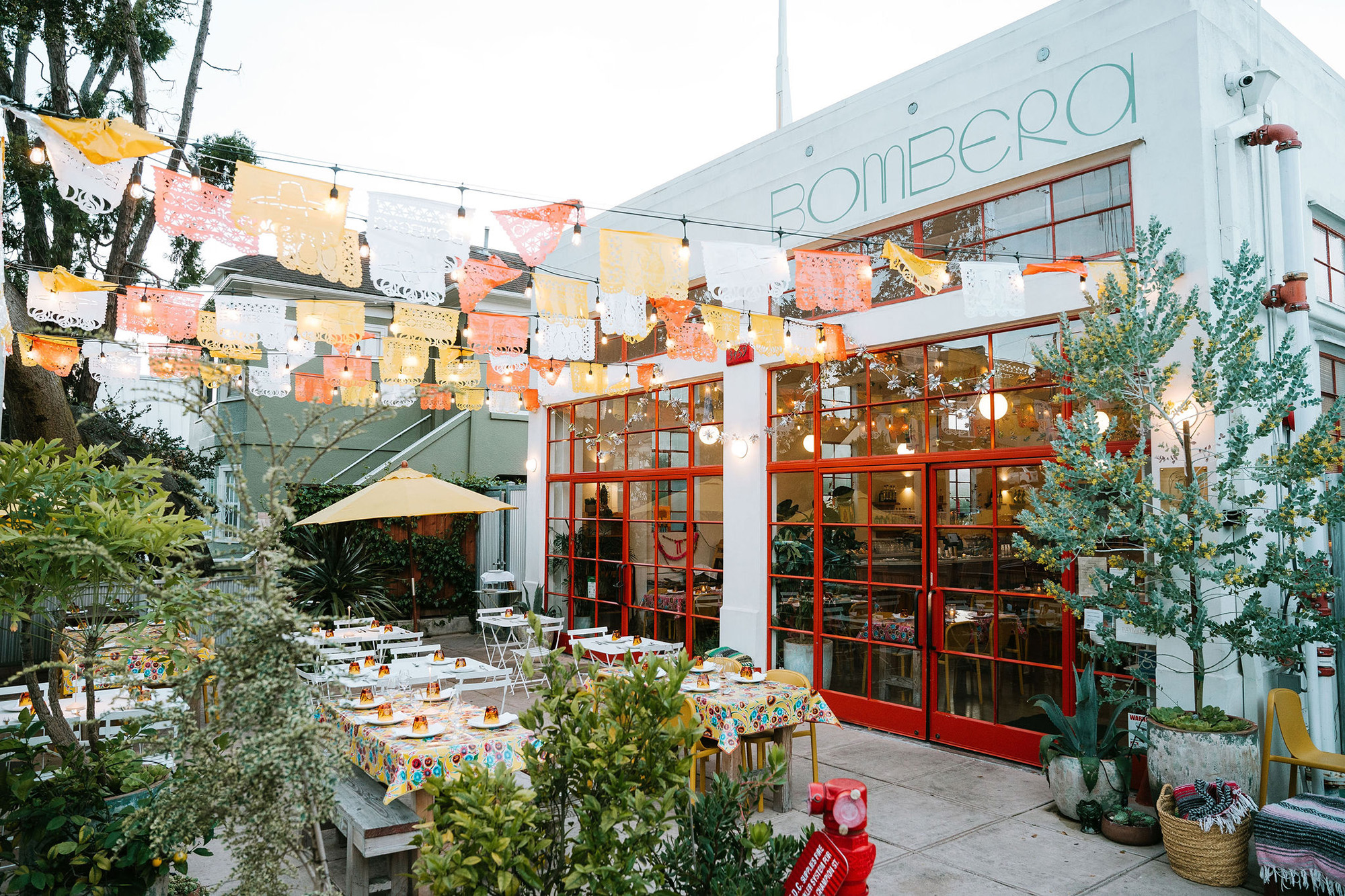 View of a restaurant courtyard decorated with festive banners. The name of the restaurant, 