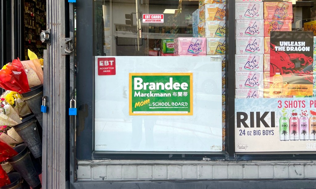 Campaign sign for Brandee Marckmann in corner store window