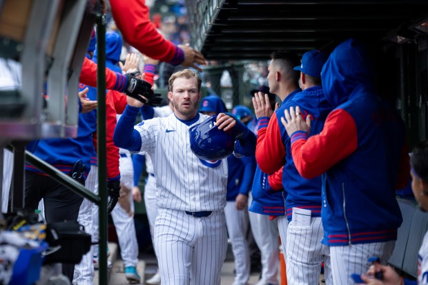 Chicago Cubs left fielder Ian Happ high fives teammates after scoring a run during the third inning of a game against the Los Angeles Angels at Wrigley Field in Chicago on Wednesday, April 1, 2026. (Josh Boland/Chicago Tribune)