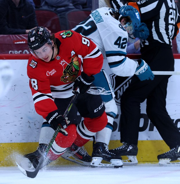 Chicago Blackhawks center Connor Bedard (98) battles San Jose Sharks defenseman Luca Cagnoni (42) along the boards in the first period of a game at the United Center in Chicago on April 15, 2026. (Chris Sweda/Chicago Tribune)