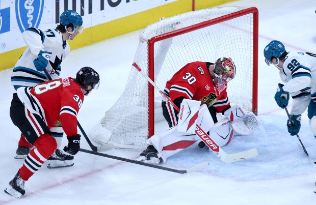 Chicago Blackhawks goaltender Spencer Knight (30) is unable to stop the puck as San Jose Sharks center Michael Misa (left) scores a goal in the second period of a game at the United Center in Chicago on April 15, 2026. (Chris Sweda/Chicago Tribune)