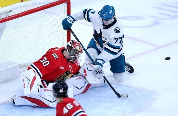 Chicago Blackhawks goaltender Spencer Knight (30) blocks away a shot by San Jose Sharks center Michael Misa (77) in the second period of a game at the United Center in Chicago on April 15, 2026. (Chris Sweda/Chicago Tribune)