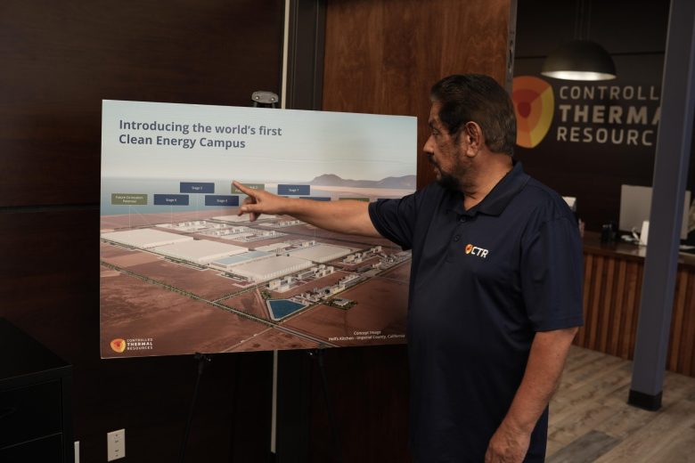 A man in a "CTR" polo shirt points at a map of a proposed clean energy campus.