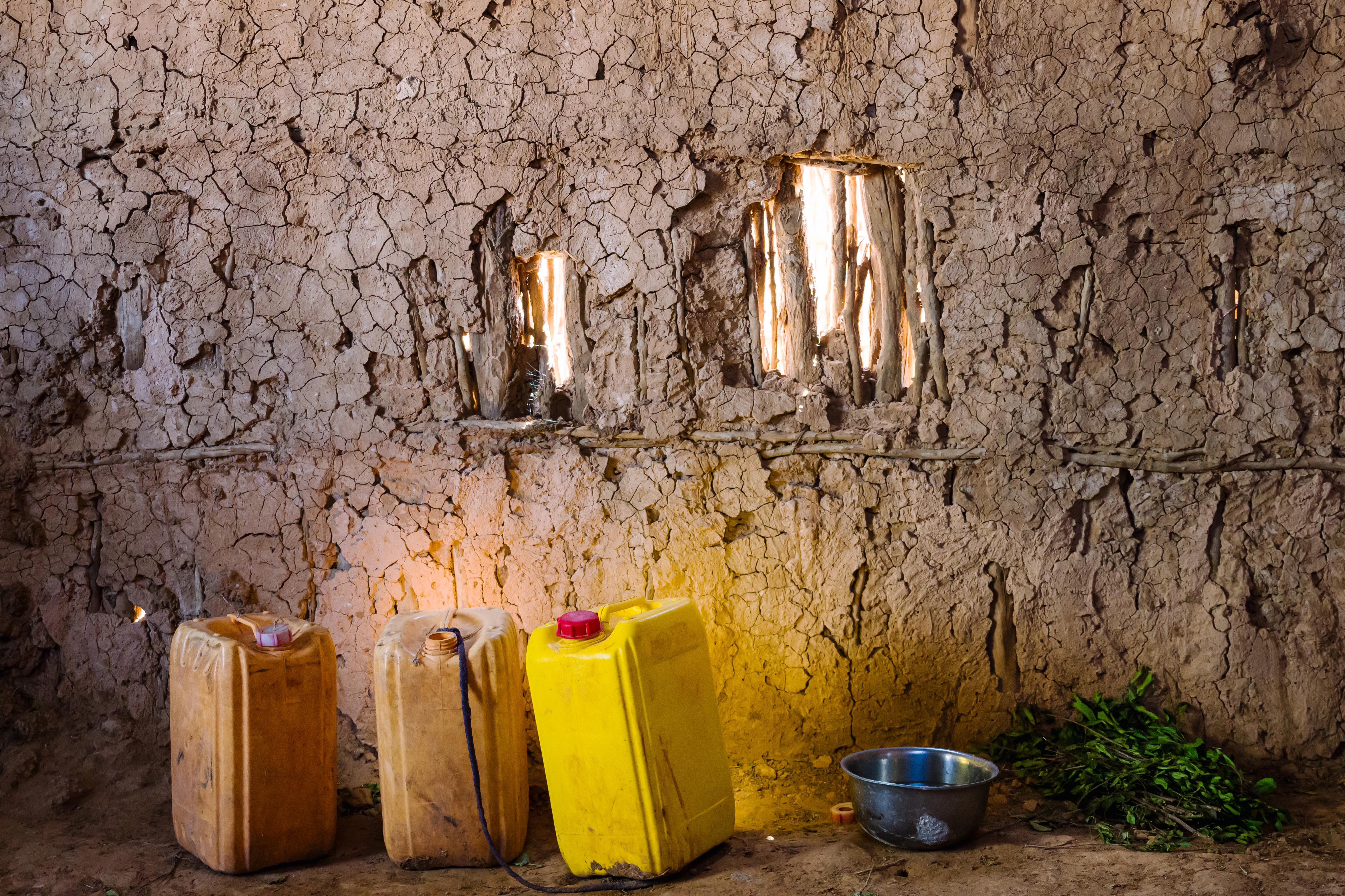 Yellow jerrycans sit next to a bowl for washing up and a pile of khat leaves.