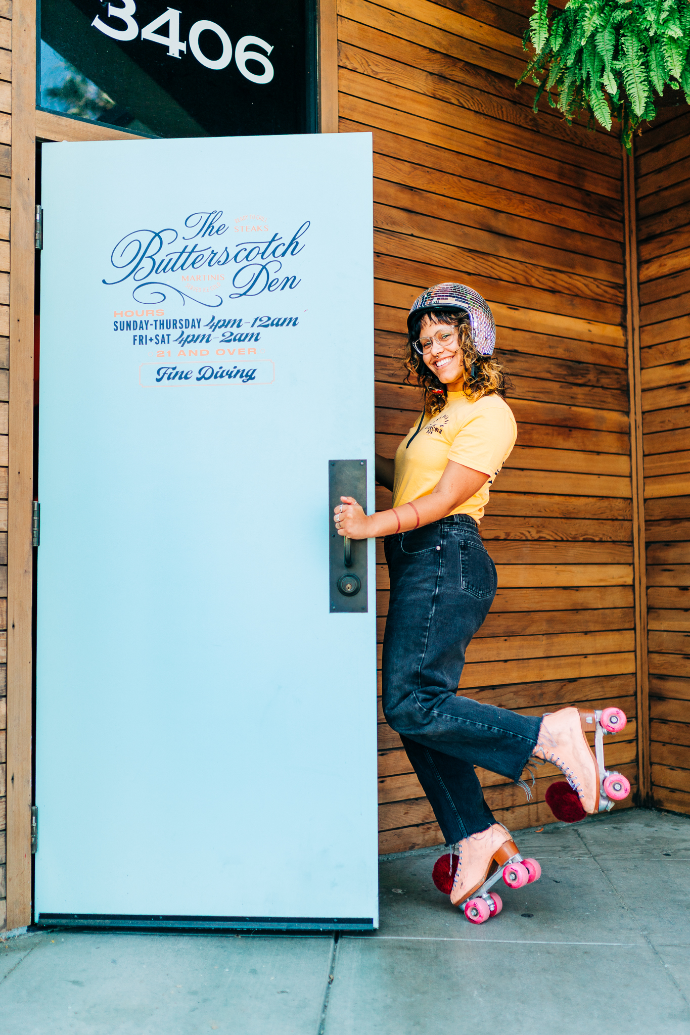 A woman on rollerskates next to the door for the Butterscotch Den.