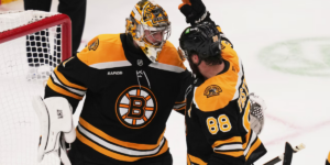 Jeremy Swayman and David Pastrnak celebrating a win
