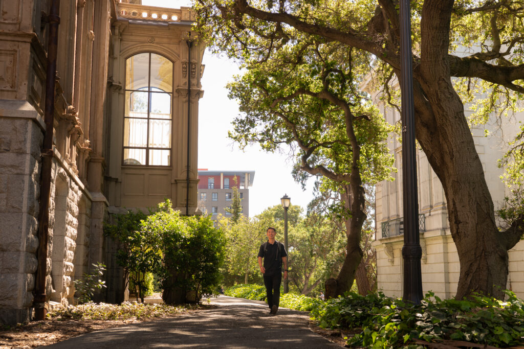 Dean Tanioka walks between buildings on the UC Berkeley campus