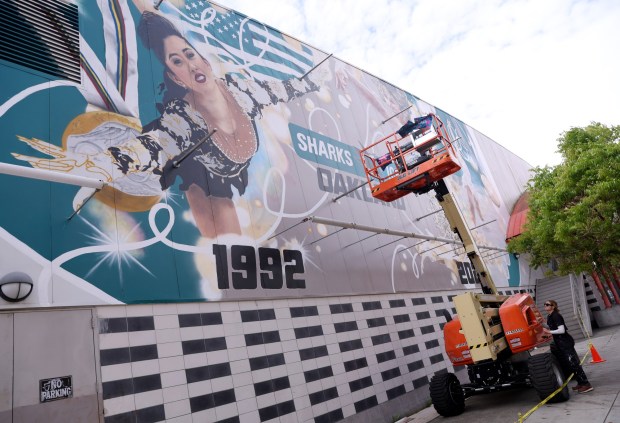 Artist Julie Engelmann, of Half Moon Bay, adjusts her lift as she works on her mural of Olympic gold medal figure skaters Alysa Liu and Kristi Yamaguchi at the Oakland Ice Center in Oakland, Calif., on Wednesday, April 15, 2026. Engelmann has worked on the mural since late March and it's nearly complete. (Jane Tyska/Bay Area News Group)