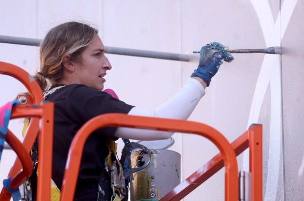 Artist Julie Engelmann, of Half Moon Bay, works on her mural of Olympic gold medal figure skaters Alysa Liu and Kristi Yamaguchi at the Oakland Ice Centerin Oakland, Calif., on Tuesday, April 7, 2026. Engelmann has worked on the mural since late March and it will be done this week. (Jane Tyska/Bay Area News Group)