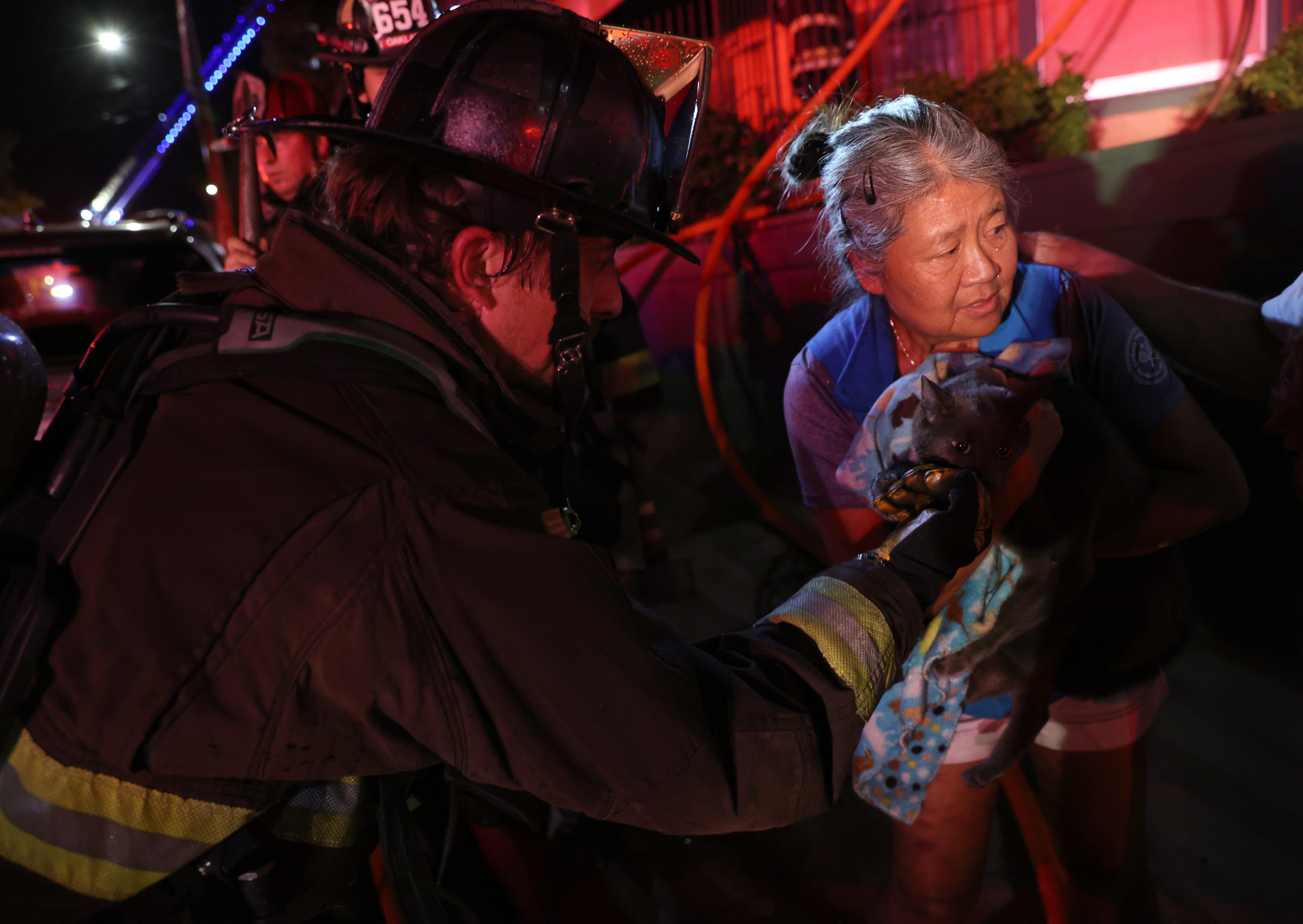 An Oakland firefighter cups his hand to give Terri Colemanâs...