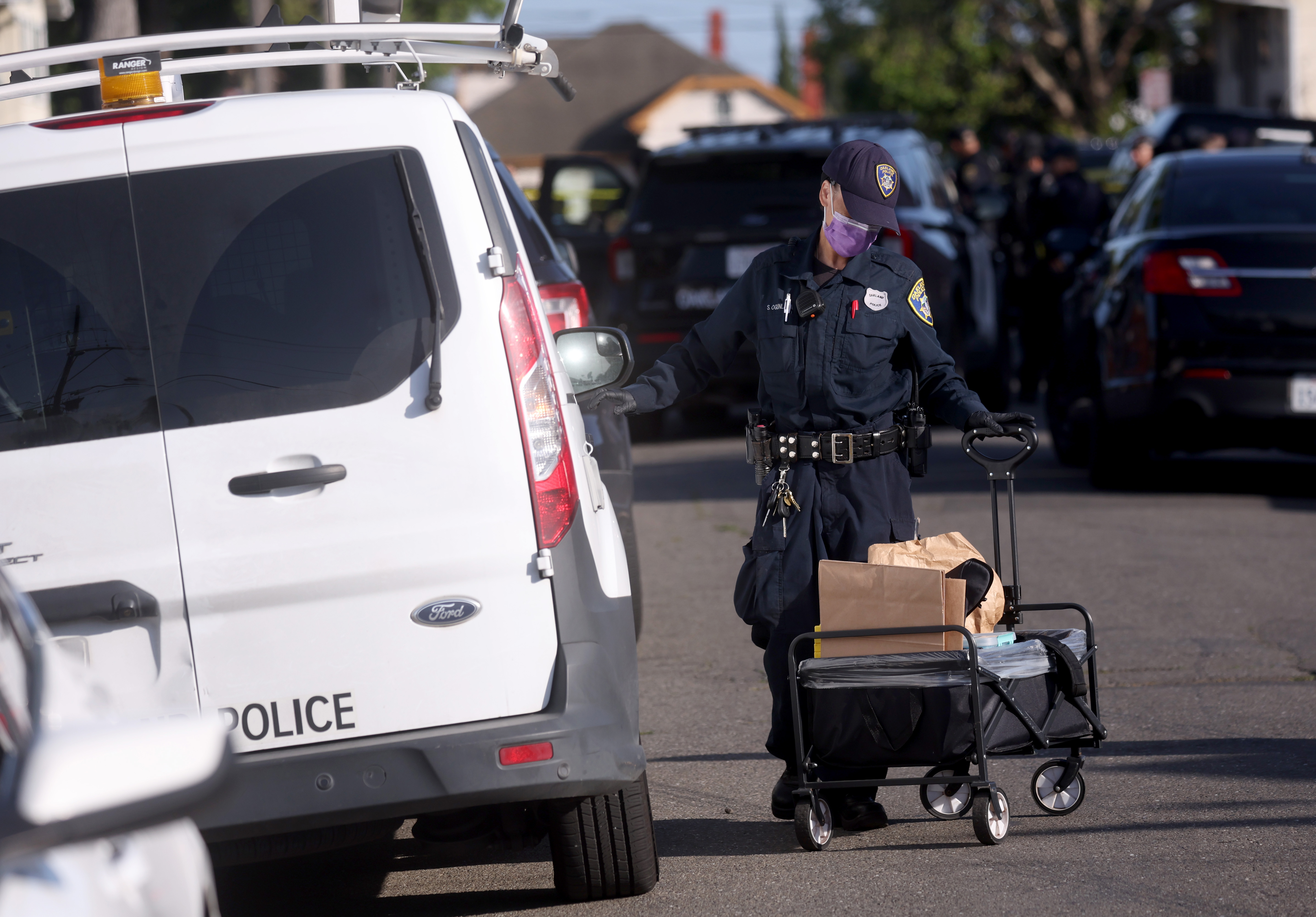 An Oakland crime scene technician prepares to investigate the scene...