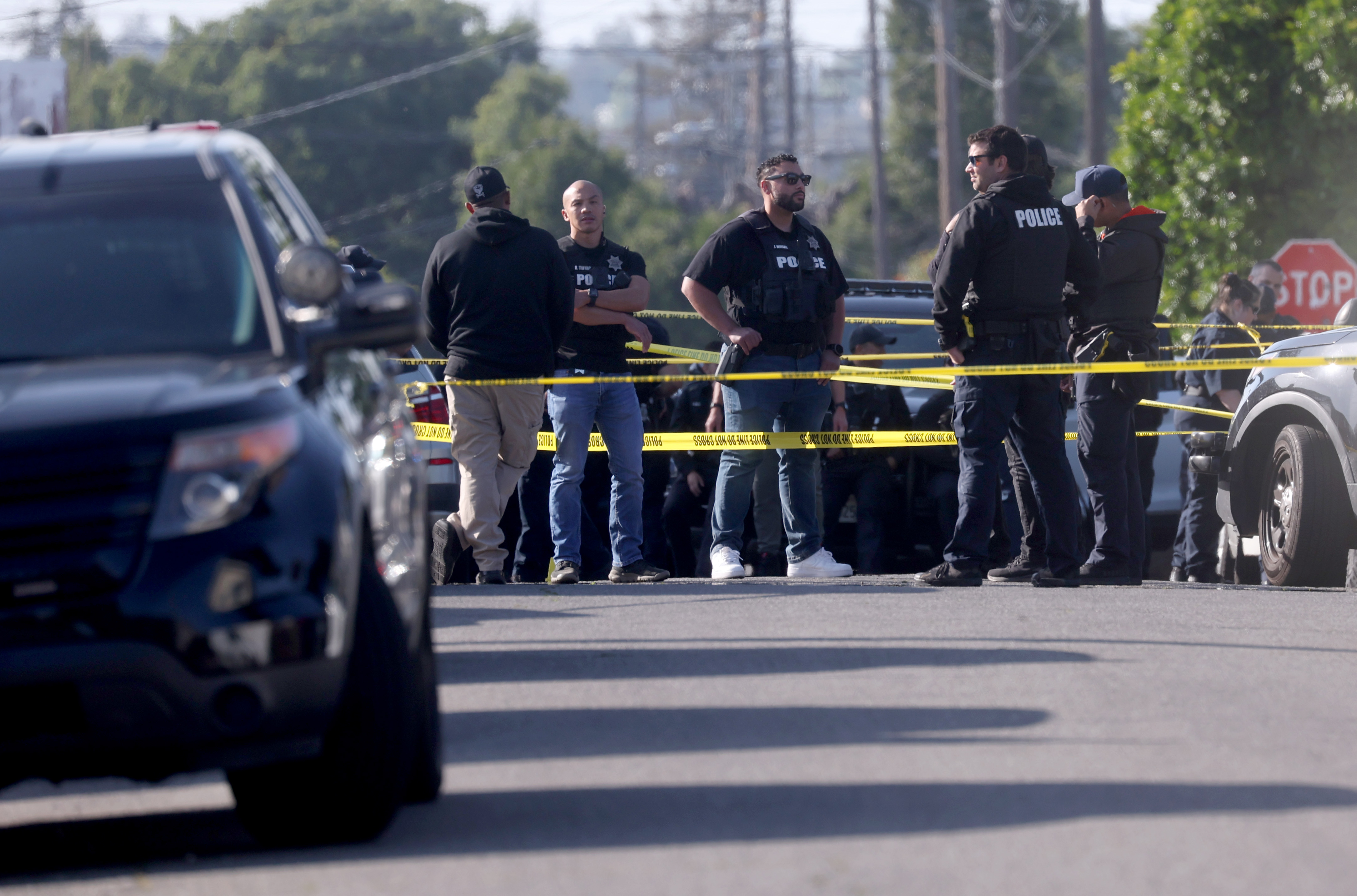 Oakland police officers investigate the scene after shooting a man...