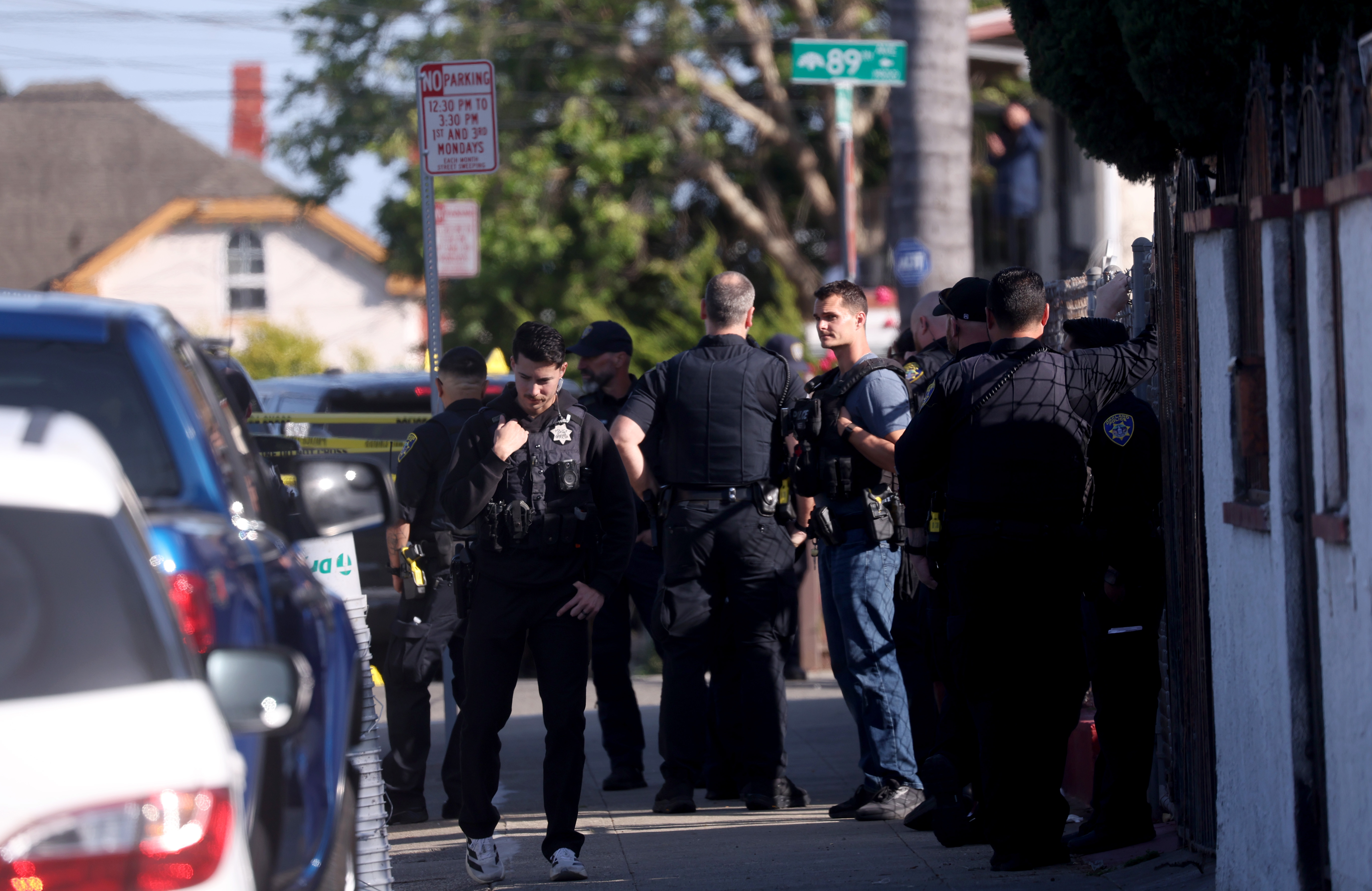 Oakland police officers investigate the scene after shooting a man...
