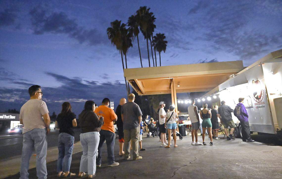Customers stand in line to order from Armando Arias Jr.'s new food truck Tacos El Cabezon, parked at the corner of Shaw and Marks avenues offering Mexicali-style Mexican food. Photographed Wednesday, Sept. 24, 2025 in Fresno.