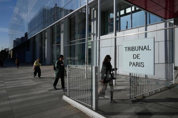 People walks in front of the Paris courthouse.