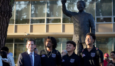 Fresno State President Saúl Jiménez-Sandoval and Fresno State students at the Nelson Mandela monument at the campus Peace Garden
