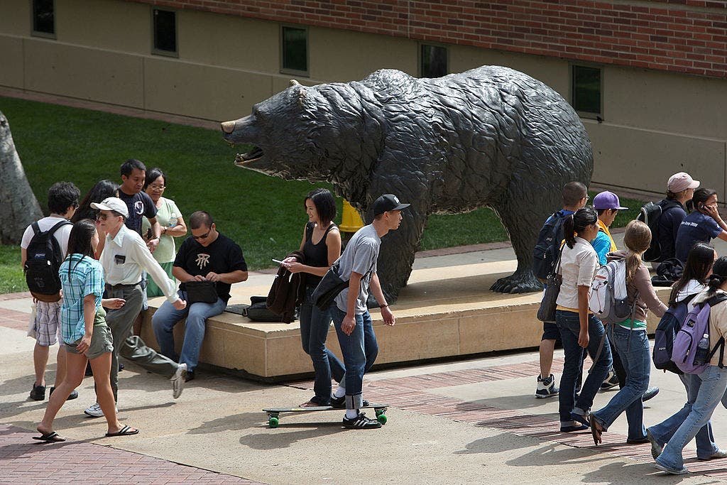 Students gather around a larger-than-life statue of a California grizzly. 