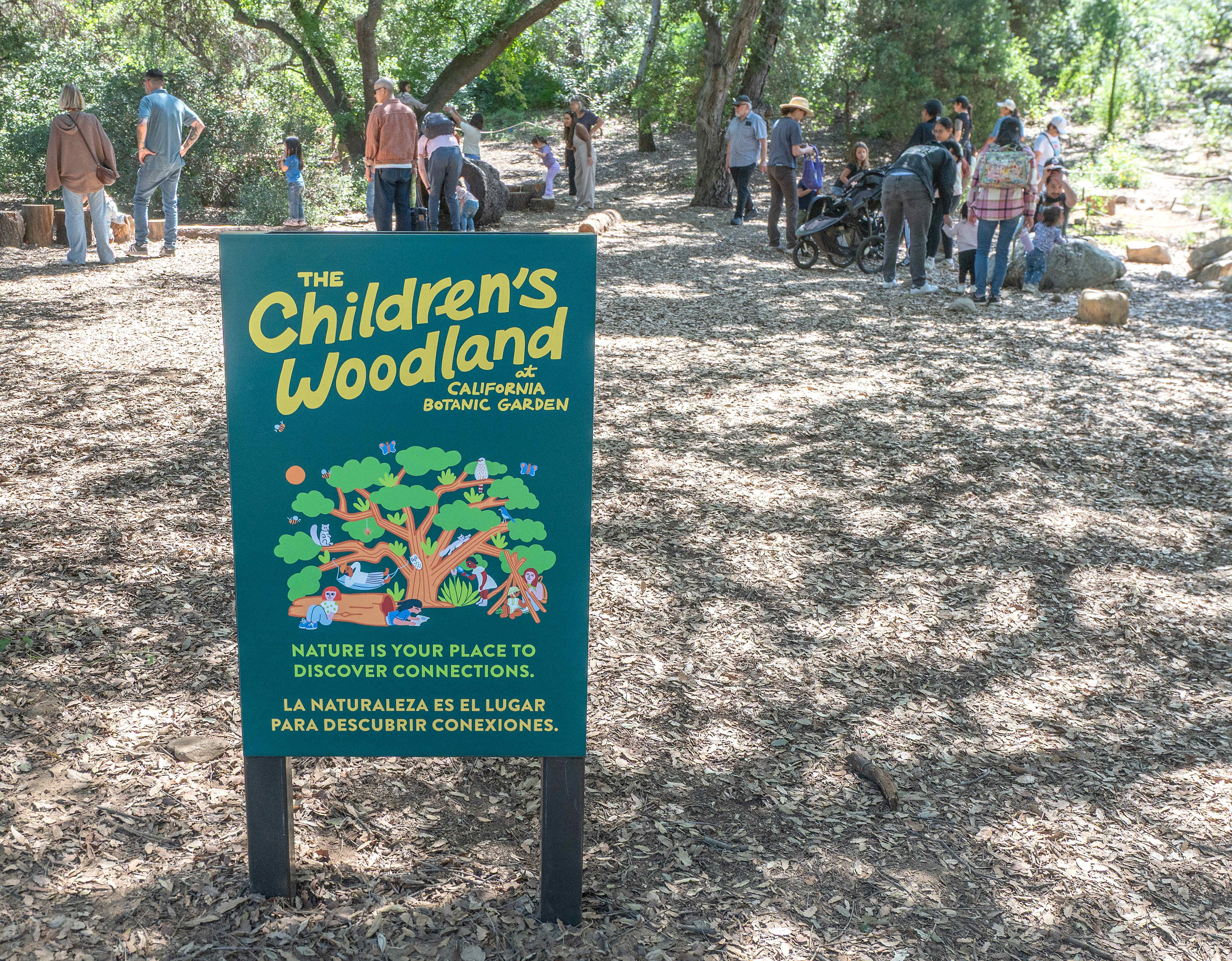Children and parents explore the 3,500-square-foot outdoor wooded area during...