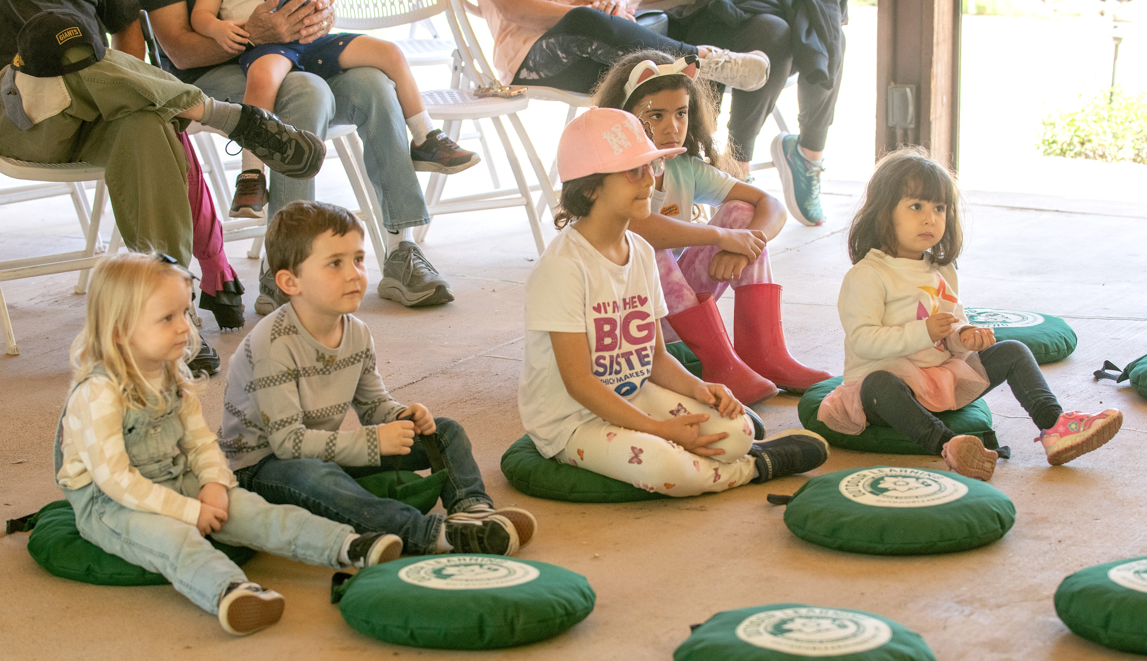 Children listen as volunteer Amy Baumann reads a book during...