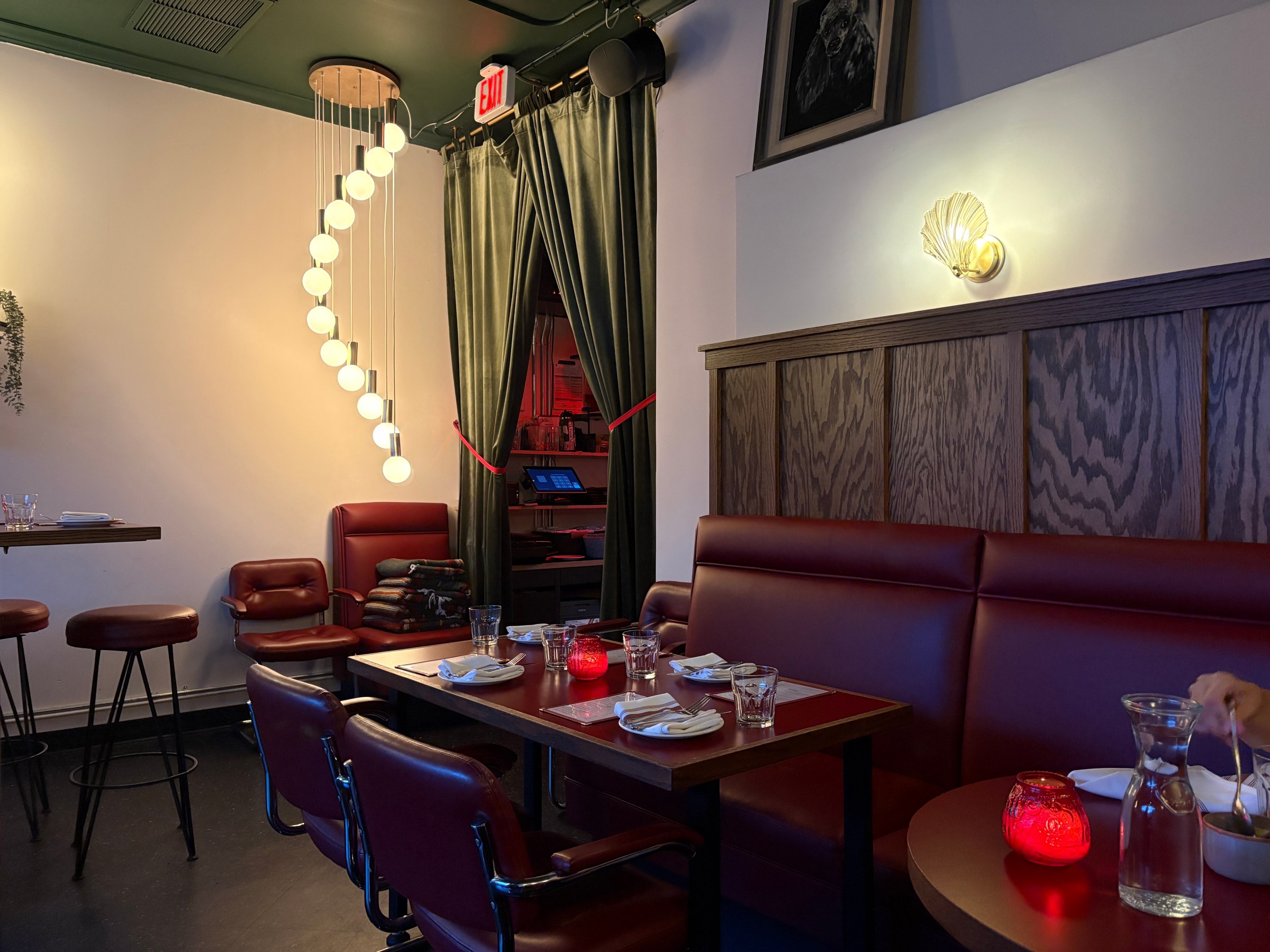Red booths and a dining room with string lamps at Bess in Sierra Madre.