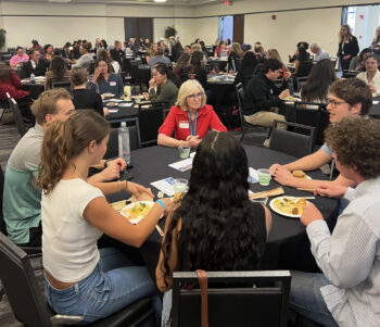 Full room of people at tables networking