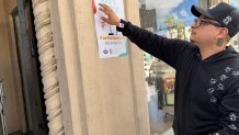 Jonathan Lopez hangs a poster for the Taste of Hillcrest, Saturday, April 11, 2026.