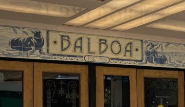 Wooden double doors beneath a sign reading "Balboa Est. 1926," decorated with illustrations of two seals on either side.