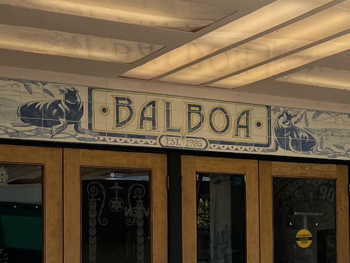 Wooden double doors beneath a sign reading "Balboa Est. 1926," decorated with illustrations of two seals on either side.
