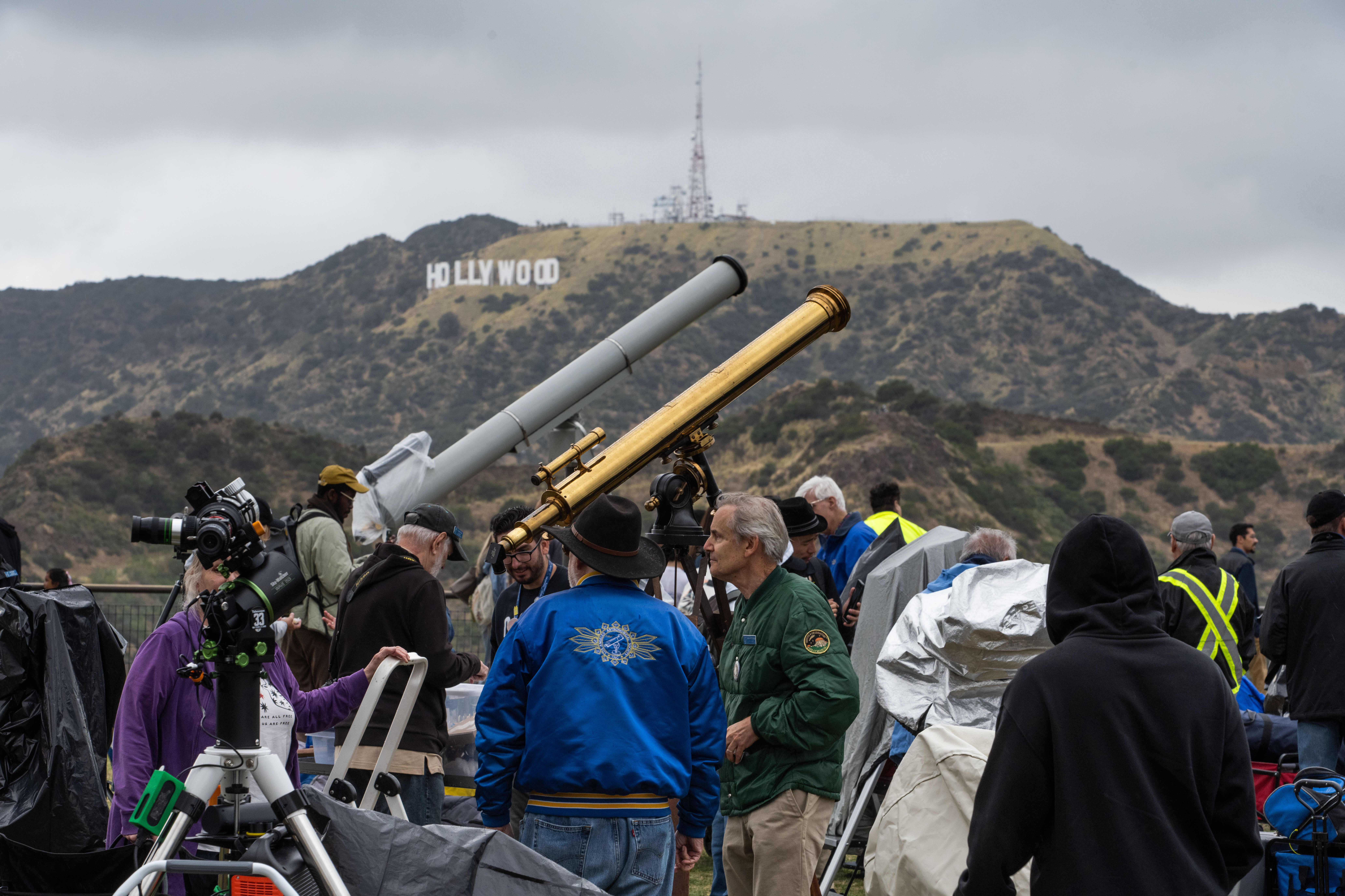 Attendees brave the rain with their telescopes during the Los...
