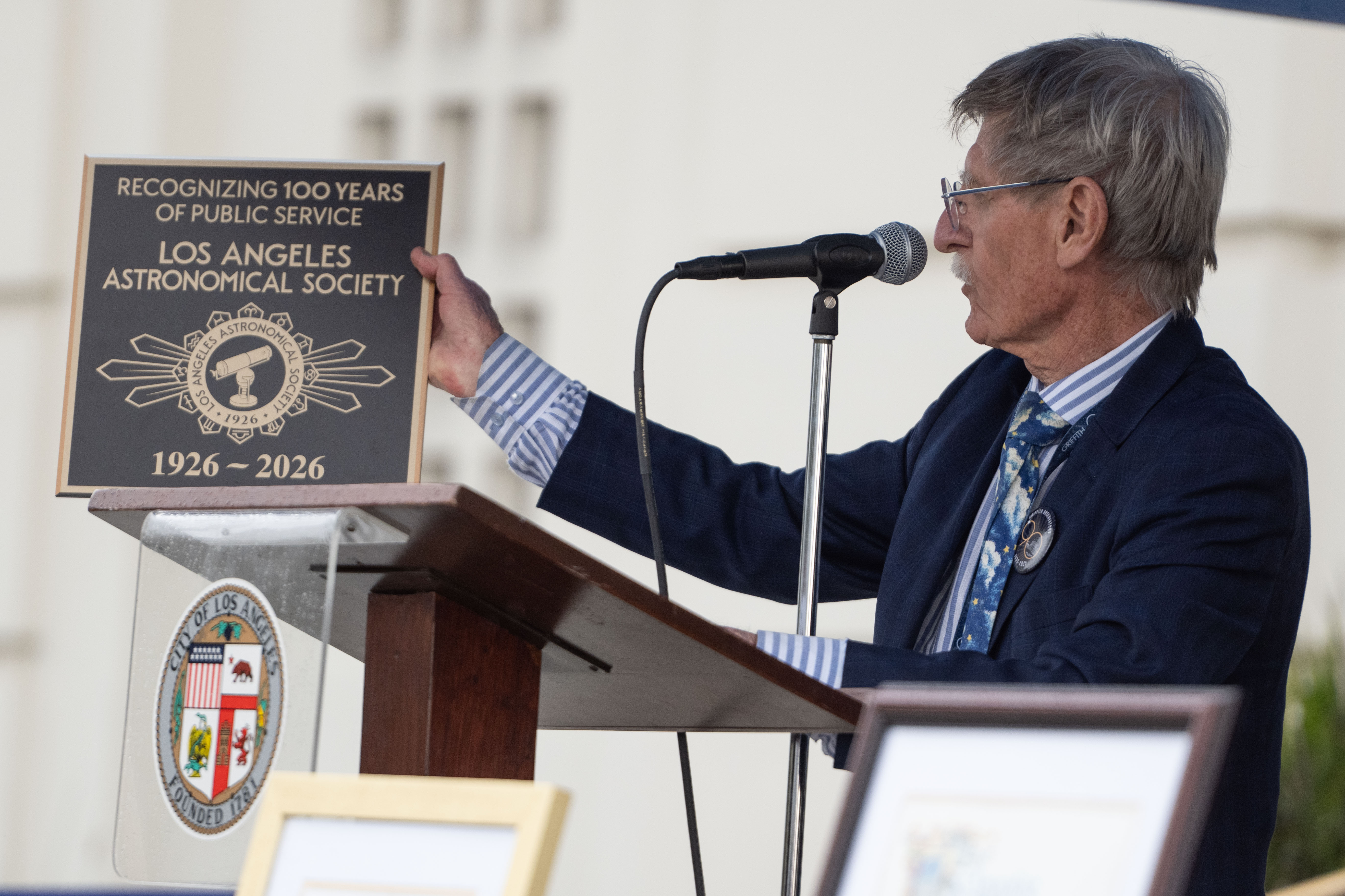 Griffith Observatory Director Dr. Ed Krupp reads from a plaque...