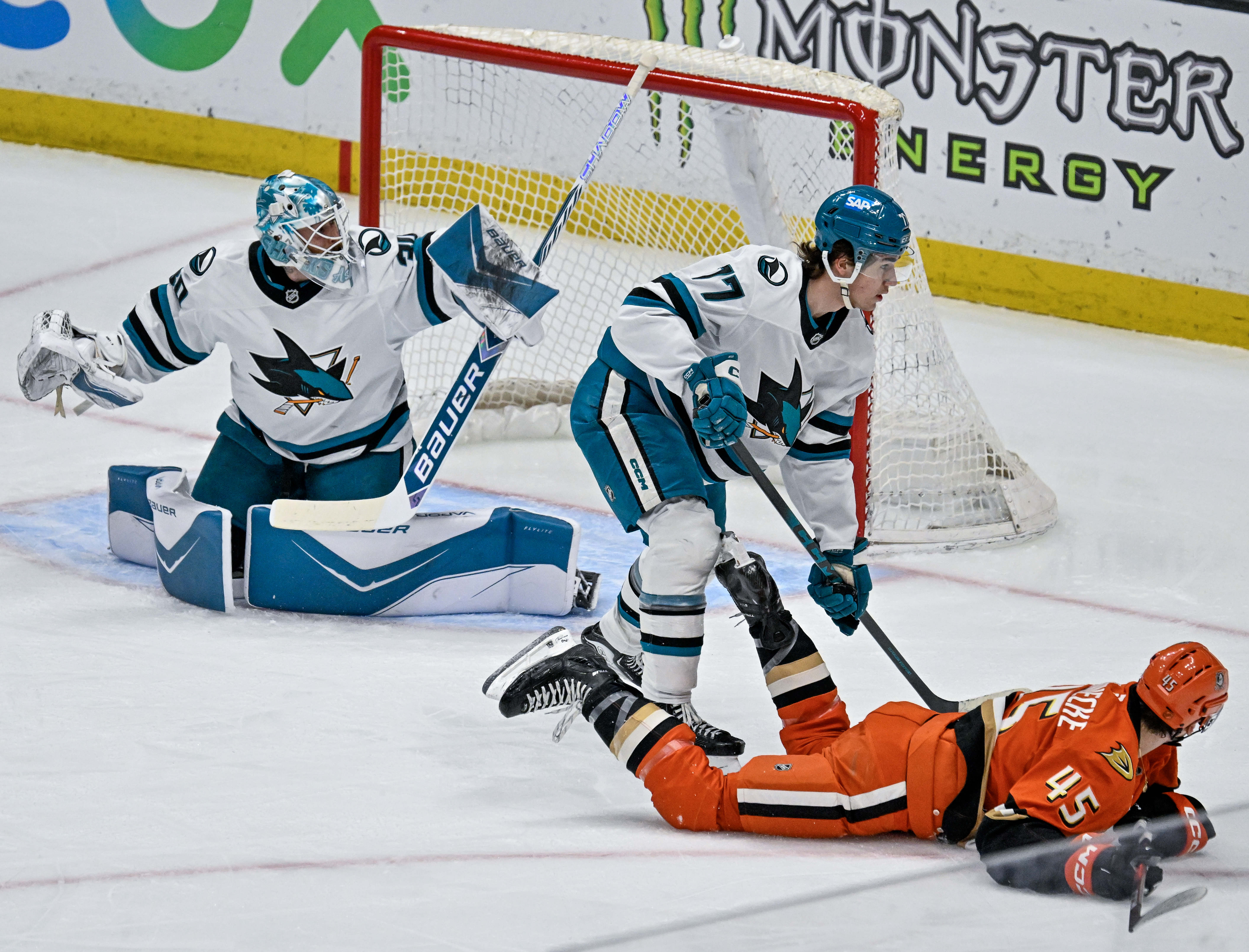 San Jose Sharks goaltender Yaroslav Askarov, left, blocks a shot...