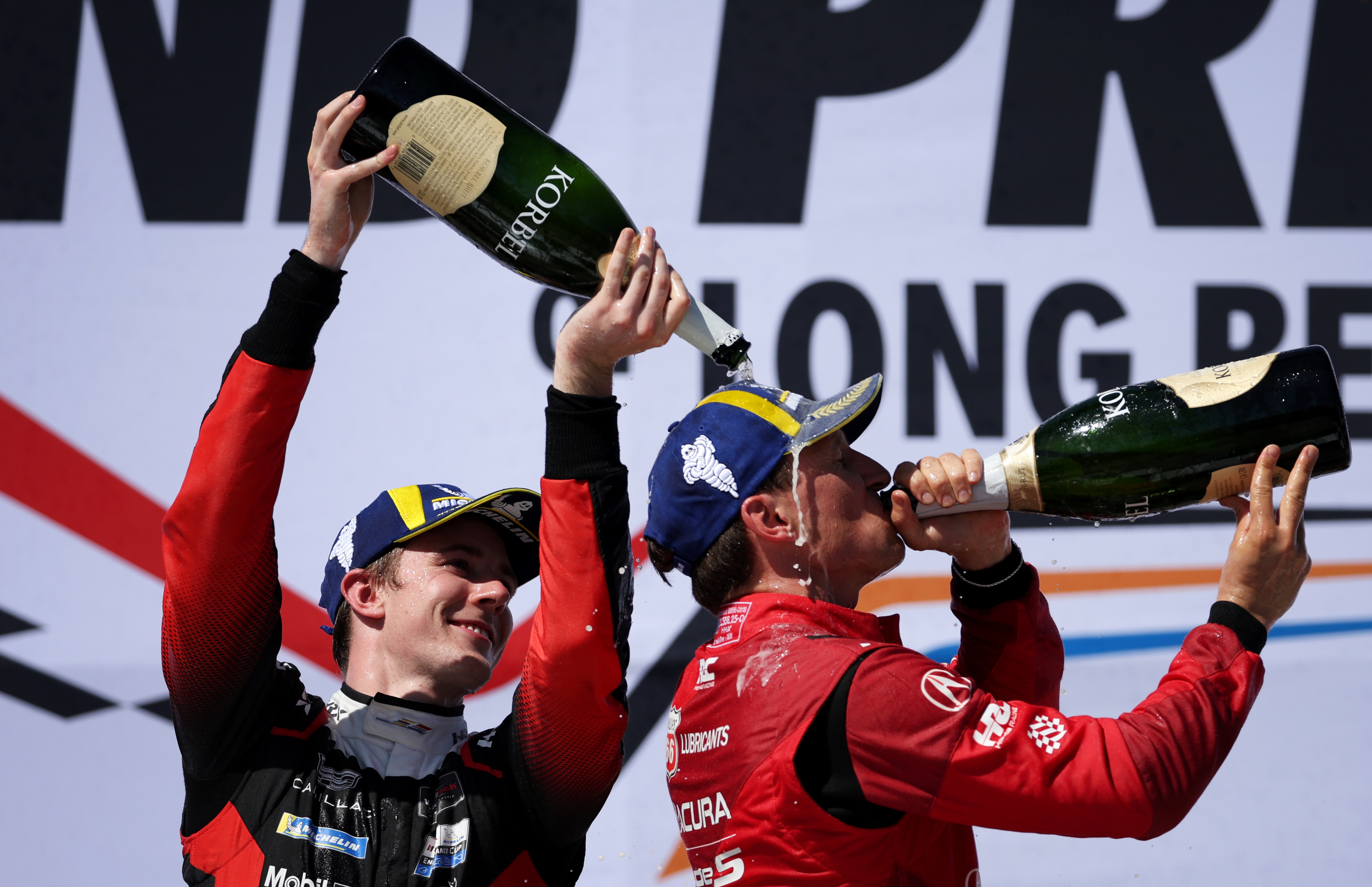 Cadillac Whelen GTP driver Frederik Vesti, left, pours champaign over...