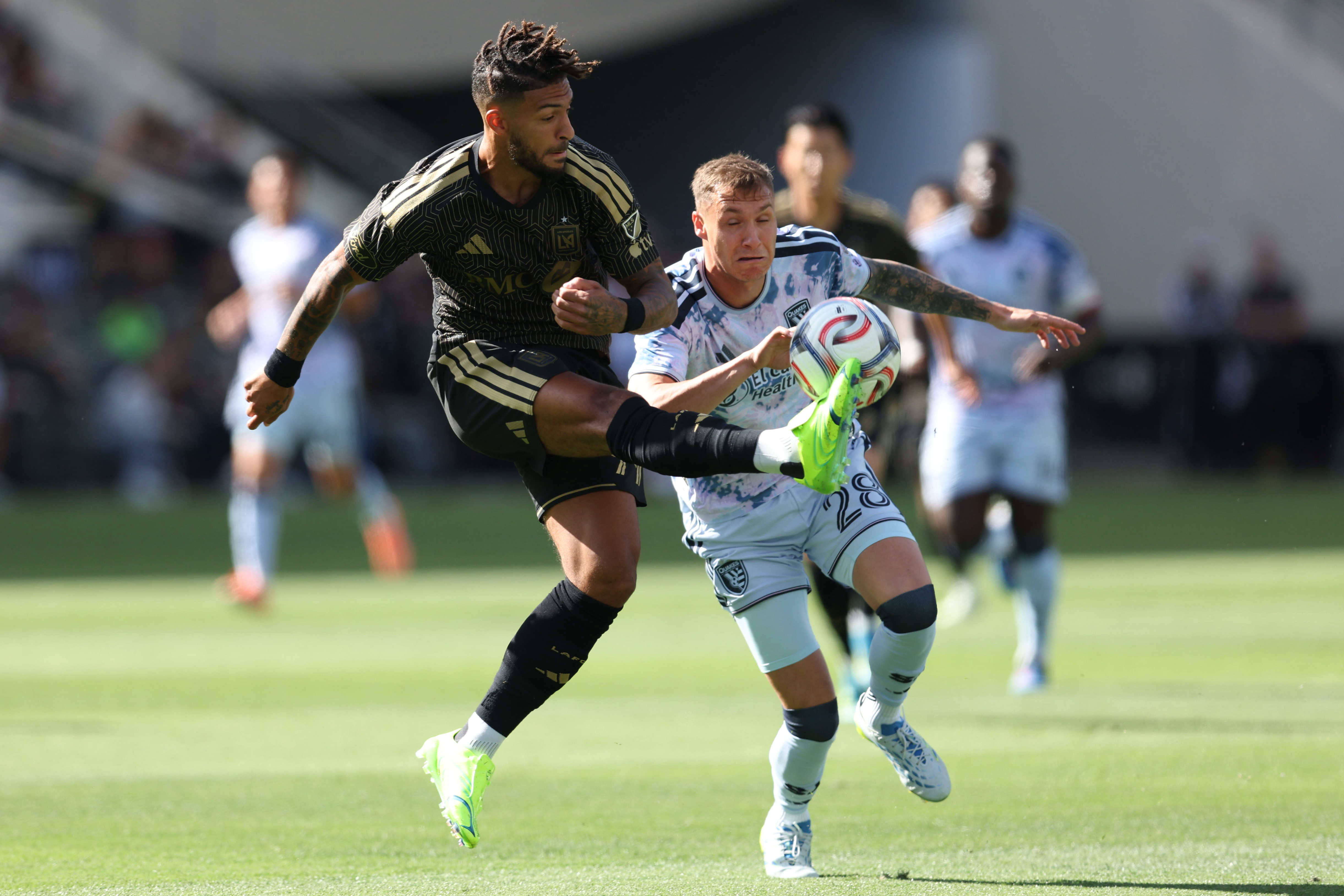 LAFC forward Denis Bouanga, front, recovers the ball defended by...