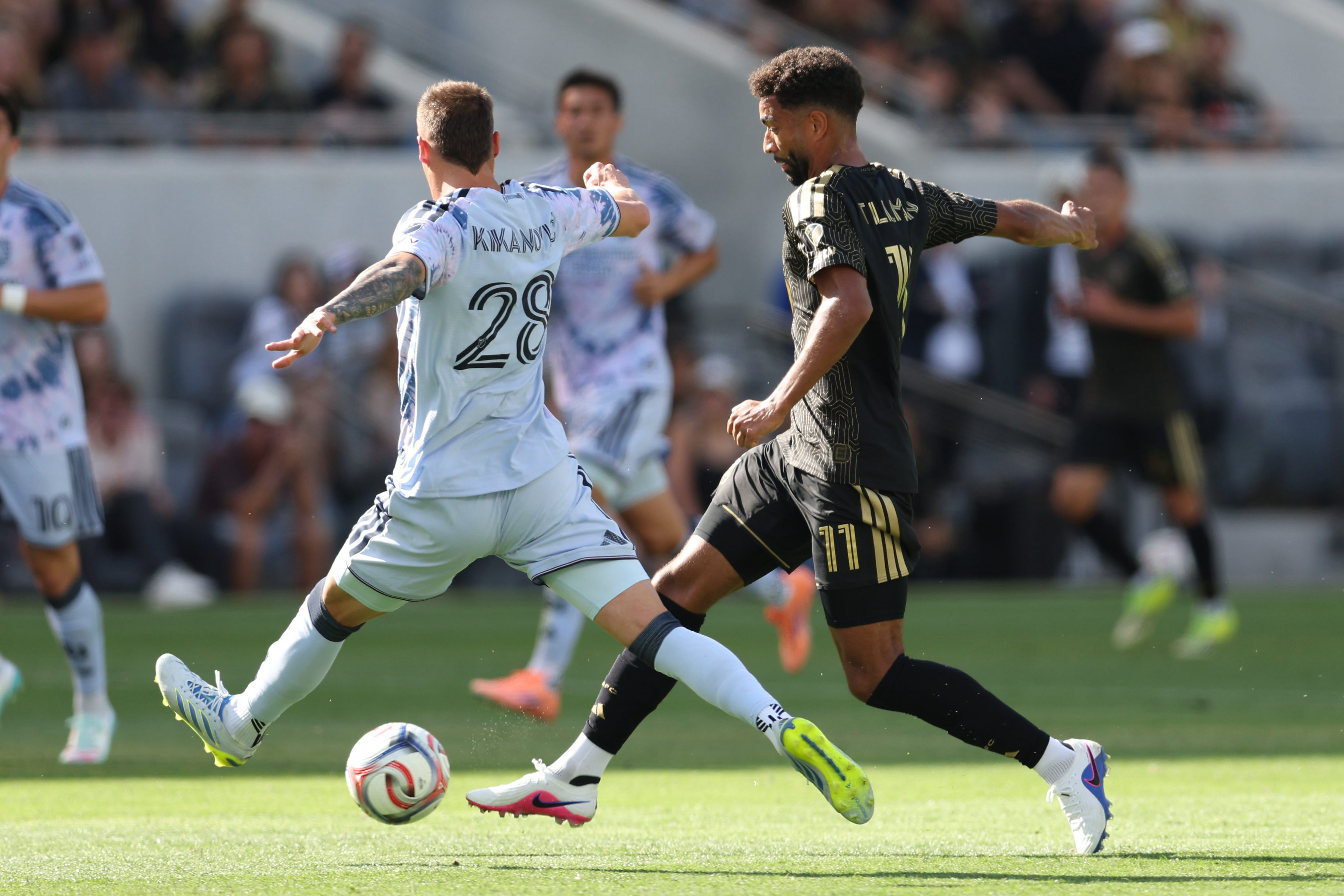 LAFC midfielder Timothy Tillman, right, kicks the ball defended by...