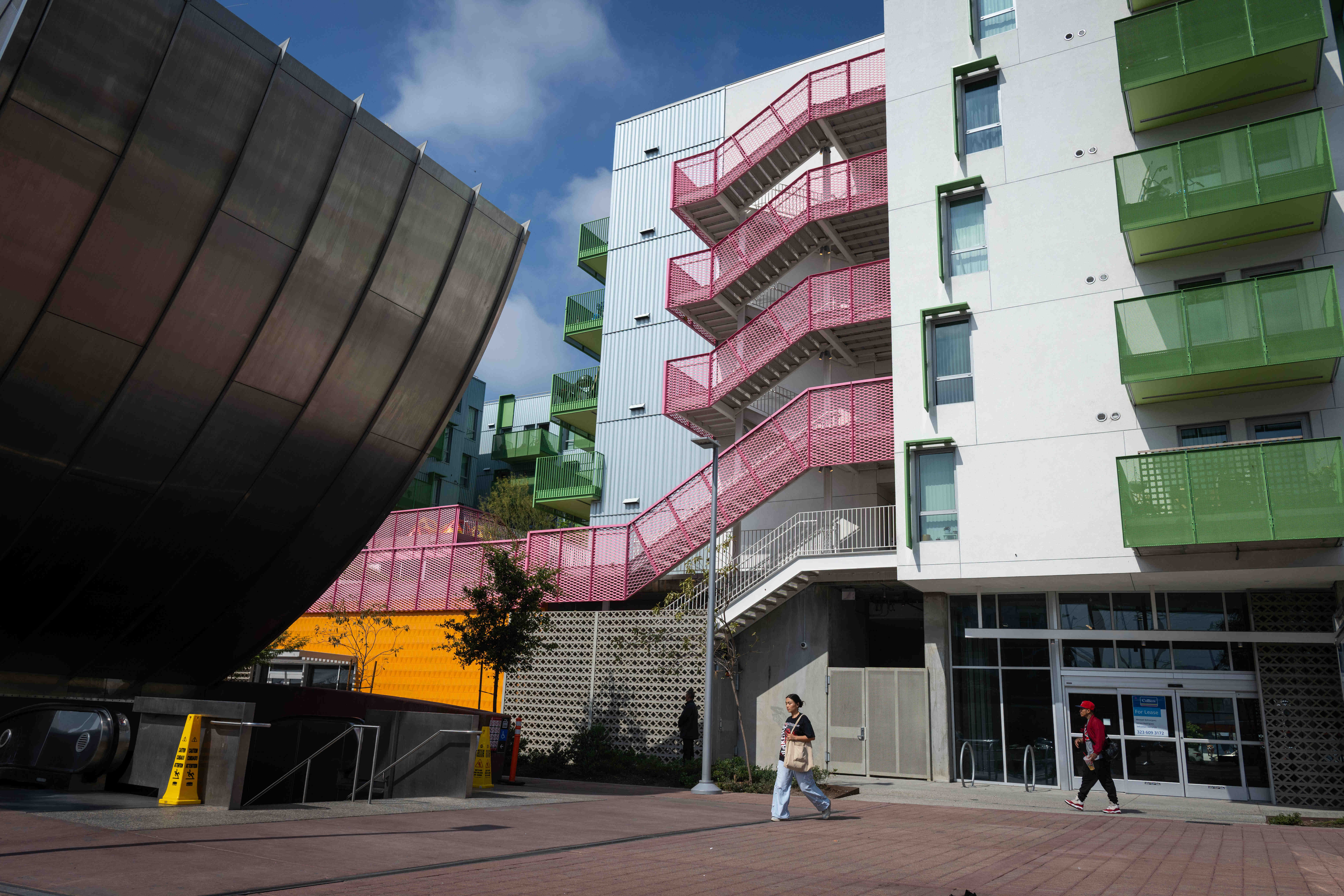 People walk past the Santa Monica and Vermont Apartments, an...