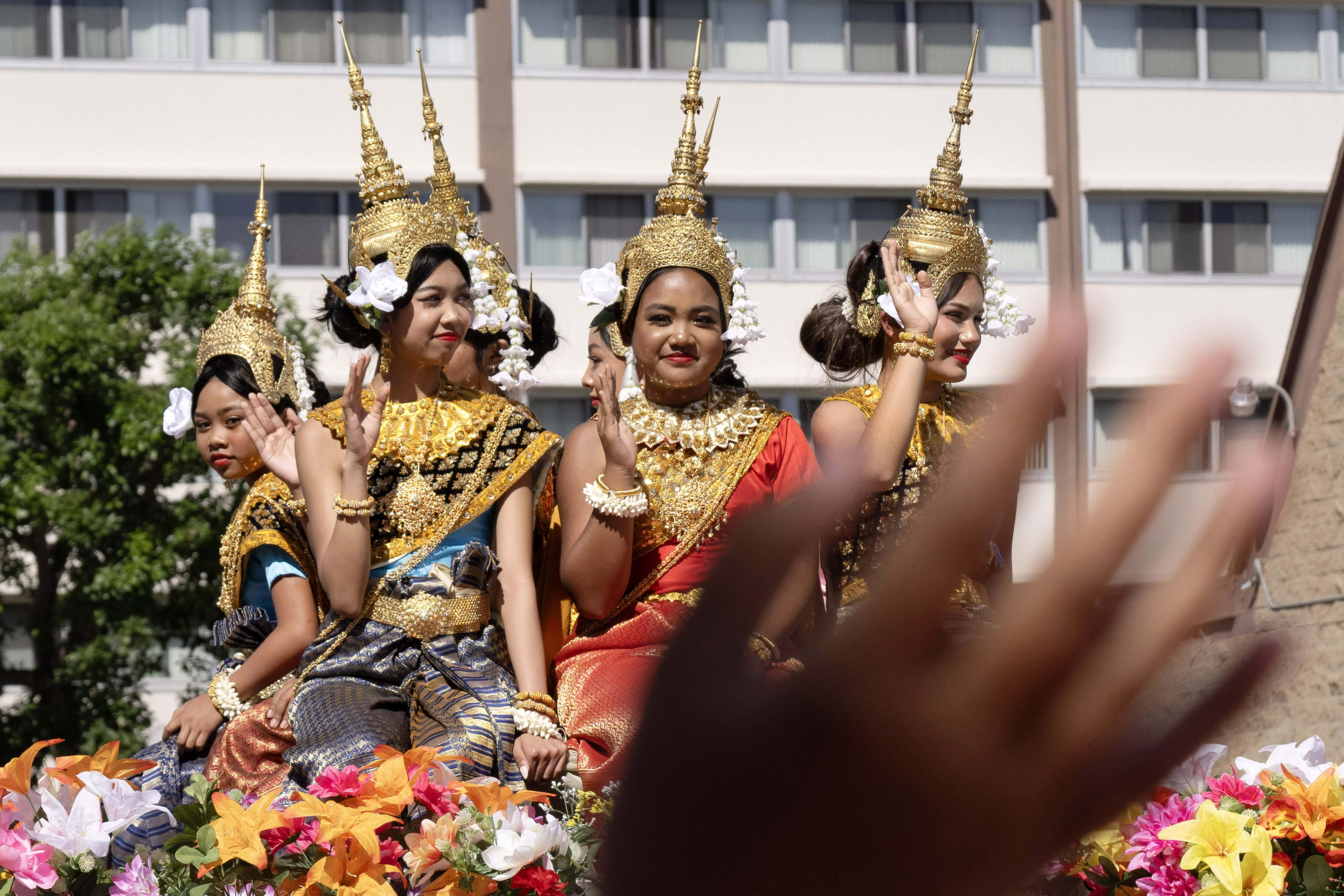 Members of the Cambodian Association of America wave to attendees...