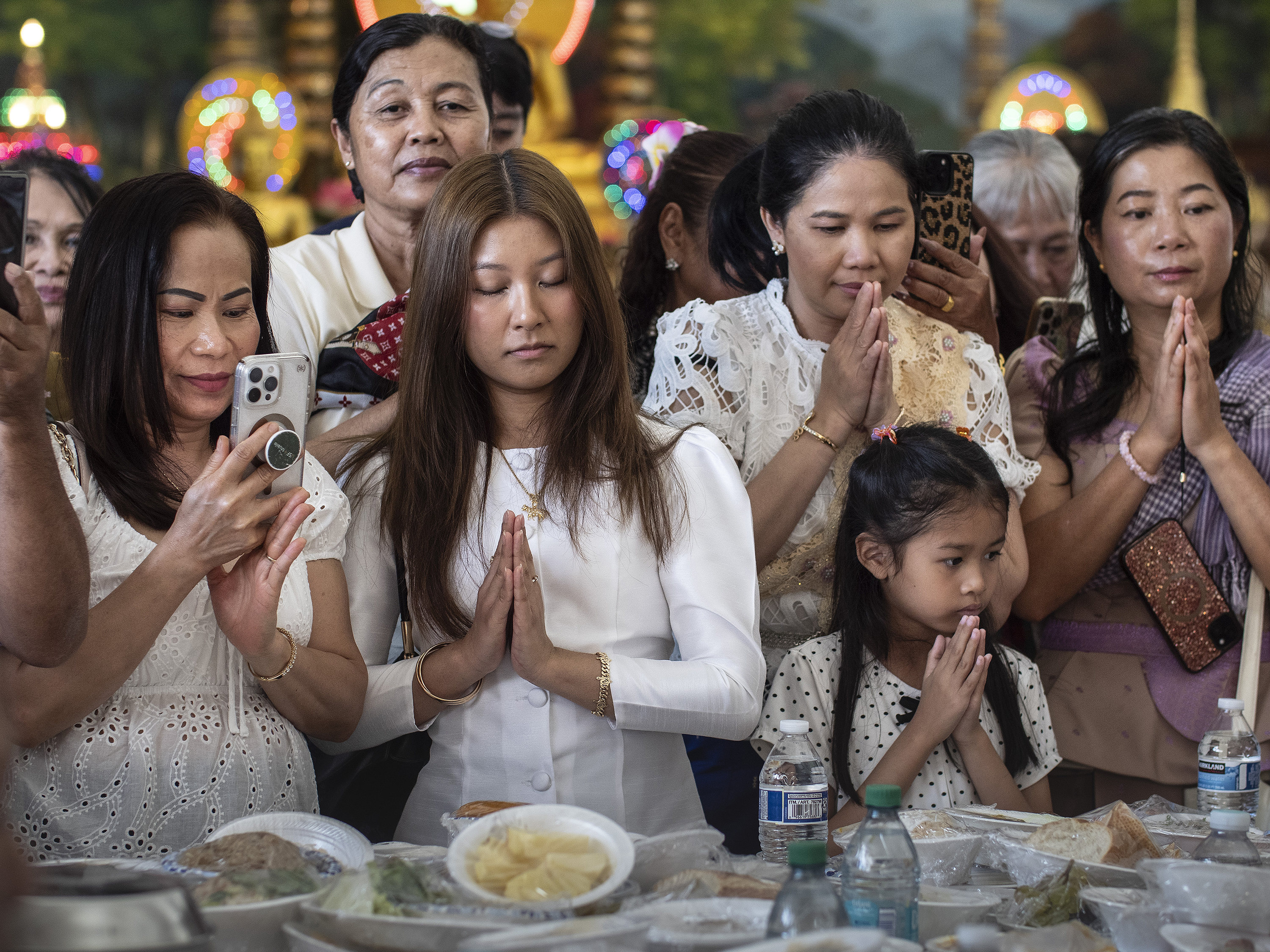 Sherry Te, 22, (center in white, eyes closed), and her...