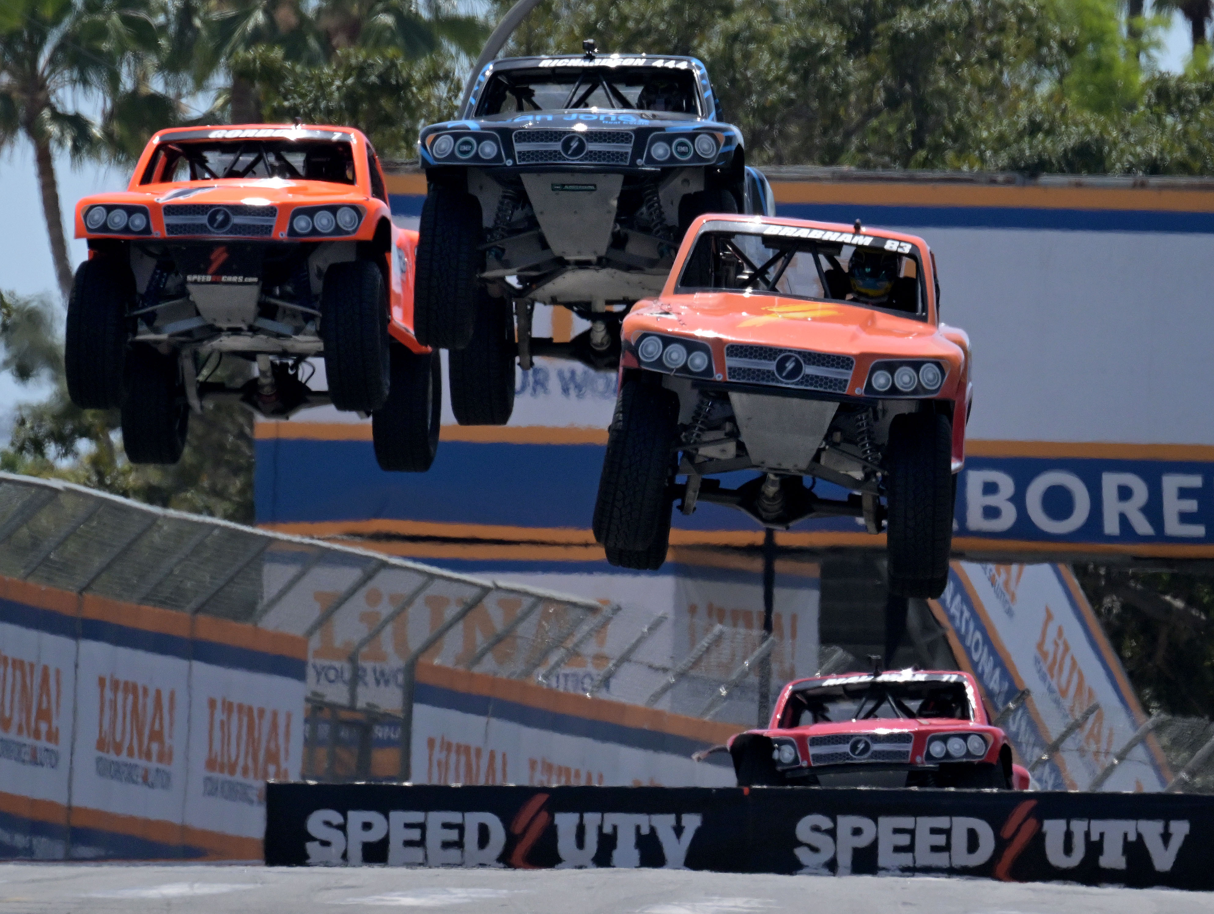 Stadium Super Truck drivers Matt Brabham, front, Robby Gordon, left,...